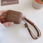 Närbild på brunt AirPods-fodral med handledsrem