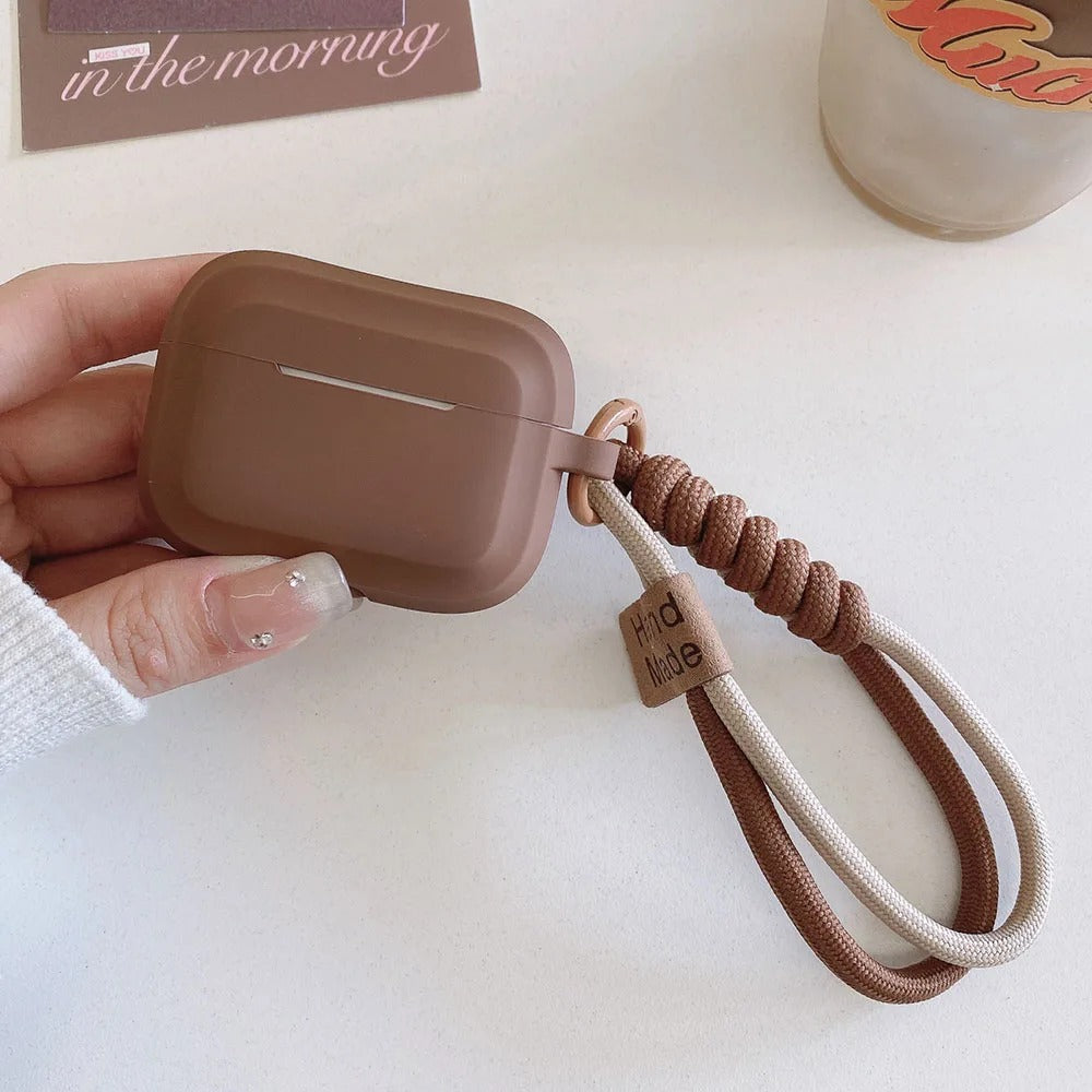 Närbild på brunt AirPods-fodral med handledsrem