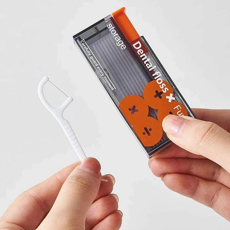 Orange tandtrådsdispenser och lös tandtrådsbygel