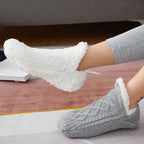 Grå stickade toffelsockor som visar det mjuka fodret