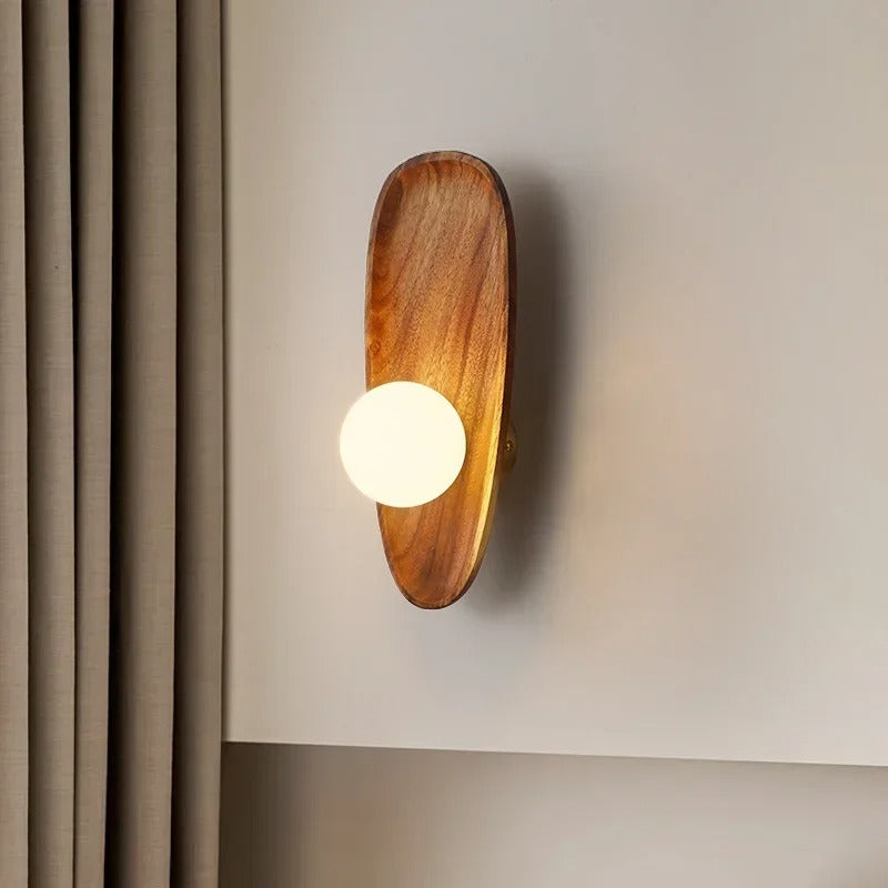 Vägglampa i trä med varm belysning vid säng