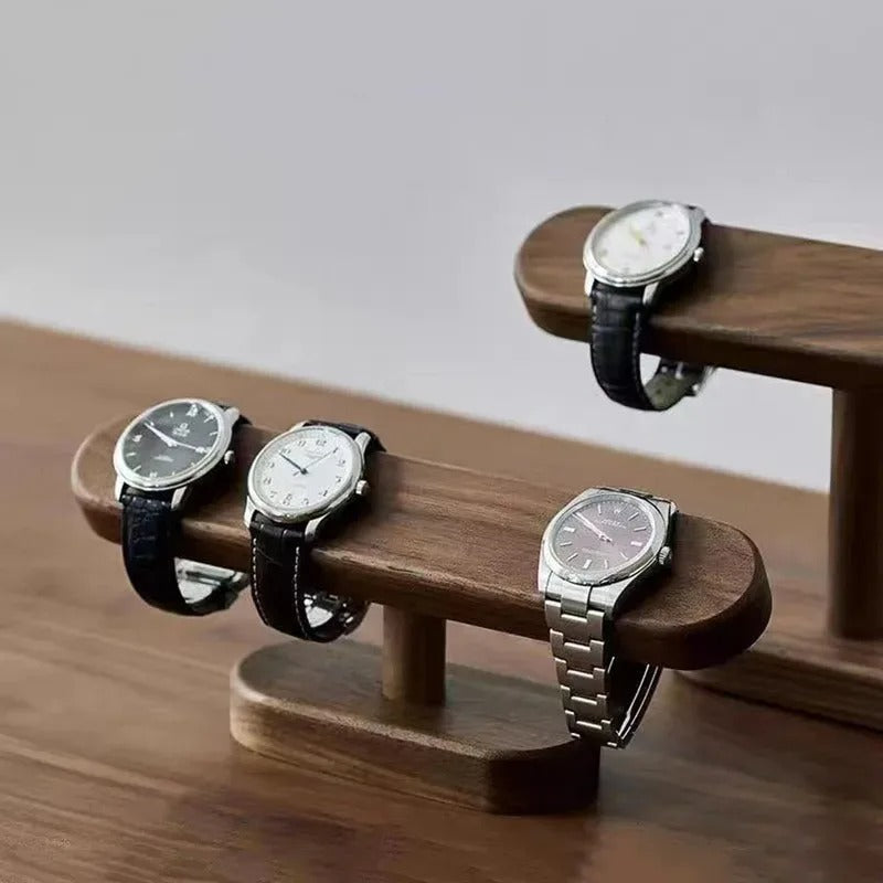 Närbild av klockställ i valnöt med armbandsur